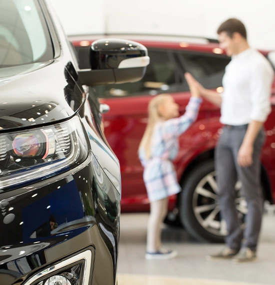 Selective focus on a car little girl high fiving her father on the background