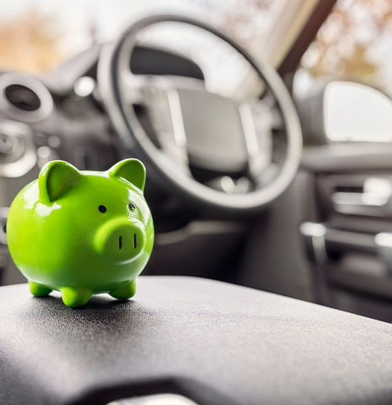 Green piggy bank money box in car interior