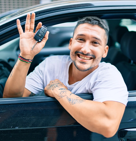 Young hispanic man smiling happy holding key of new car
