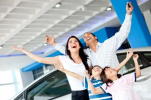 Excited family at the dealer buying a car and celebrating