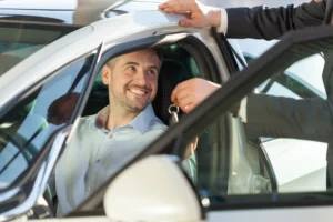 Picture of showroom client sitting in his new car